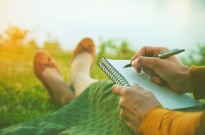 Writing No Matter What female hands with pen writing on notebook on grass outside